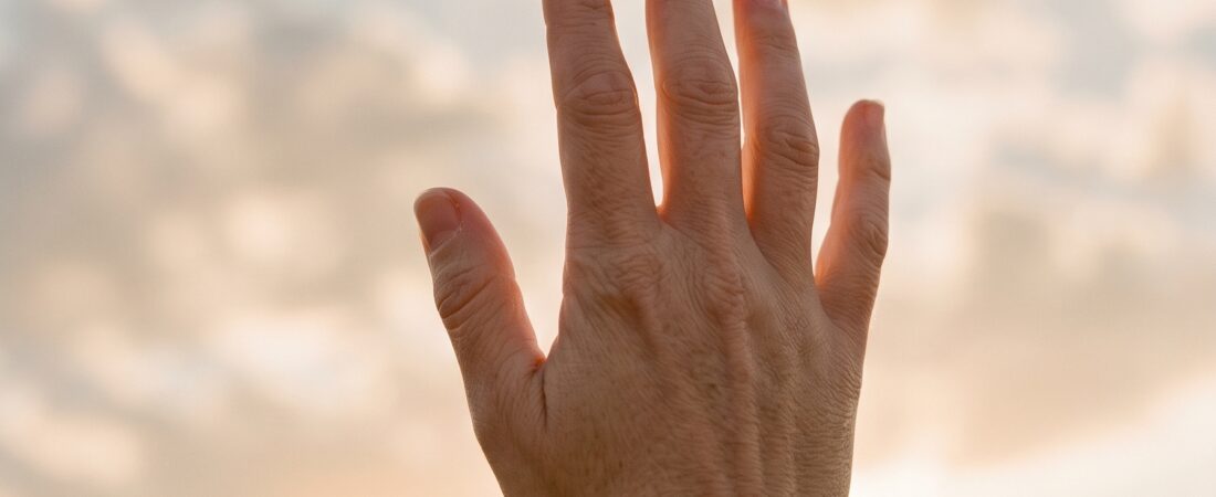 Hand in gouden zonlicht — reiken naar je bestemming