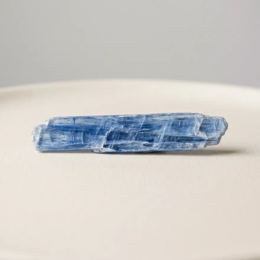 Ruwe blauwe kyaniet met karakteristieke bladerige structuur op een lichte achtergrond