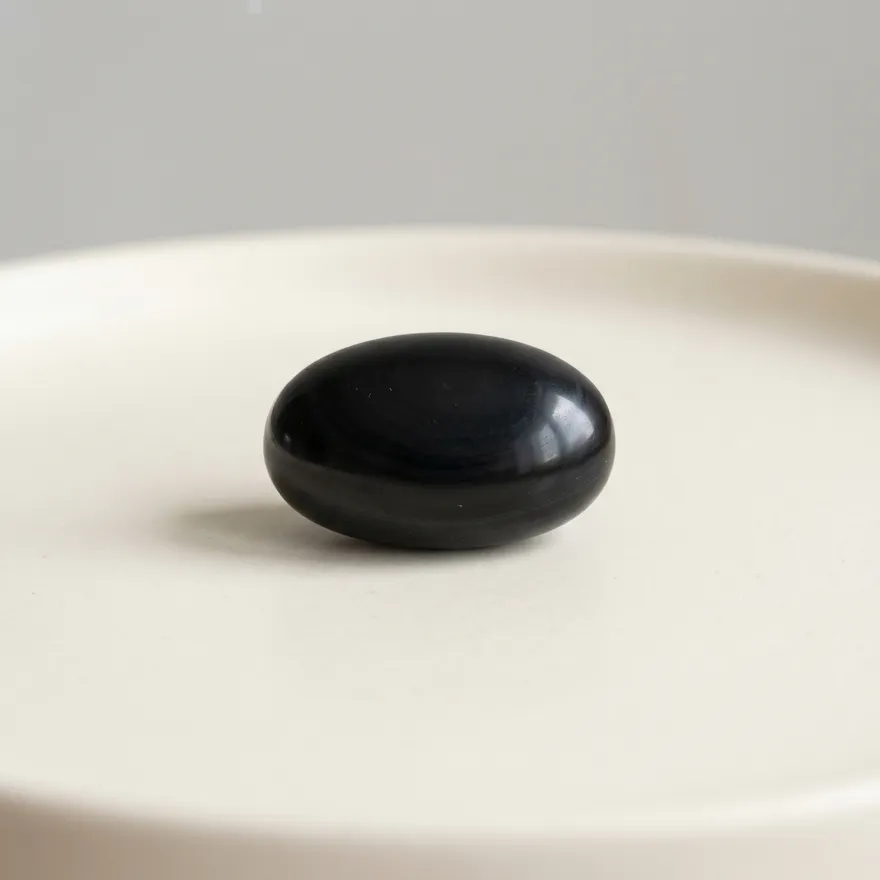 Gladde zwarte onyx steen op een lichte achtergrond